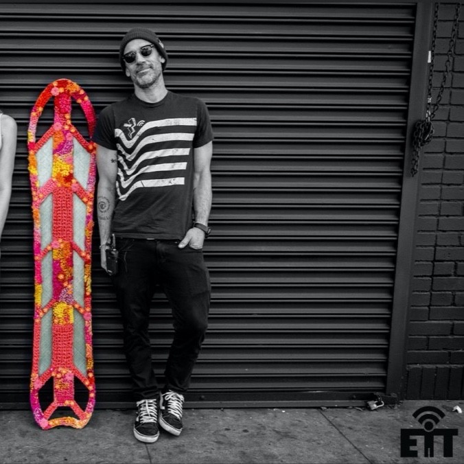 Monochromatic photo of a man next to a colorful board