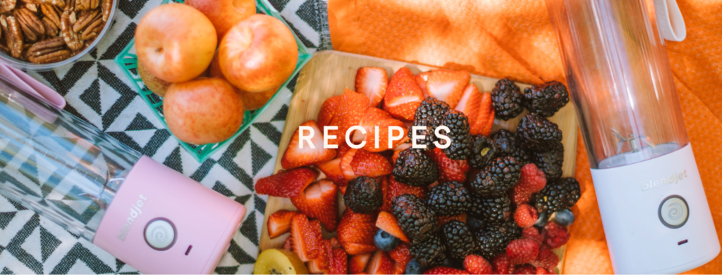 Berries and other fruit are shown along with a white blender on the right, and a pink blender on the left. The word recipes is in the center.