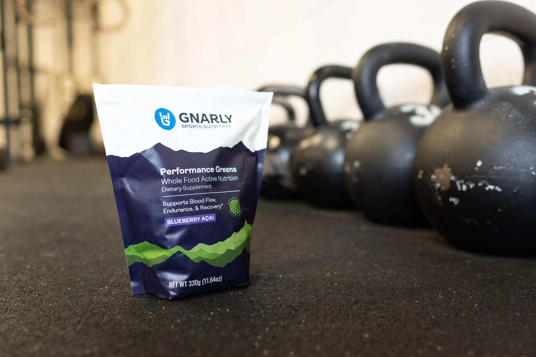 Gnarly Nutrition packet sitting next to kettle bells in a gym