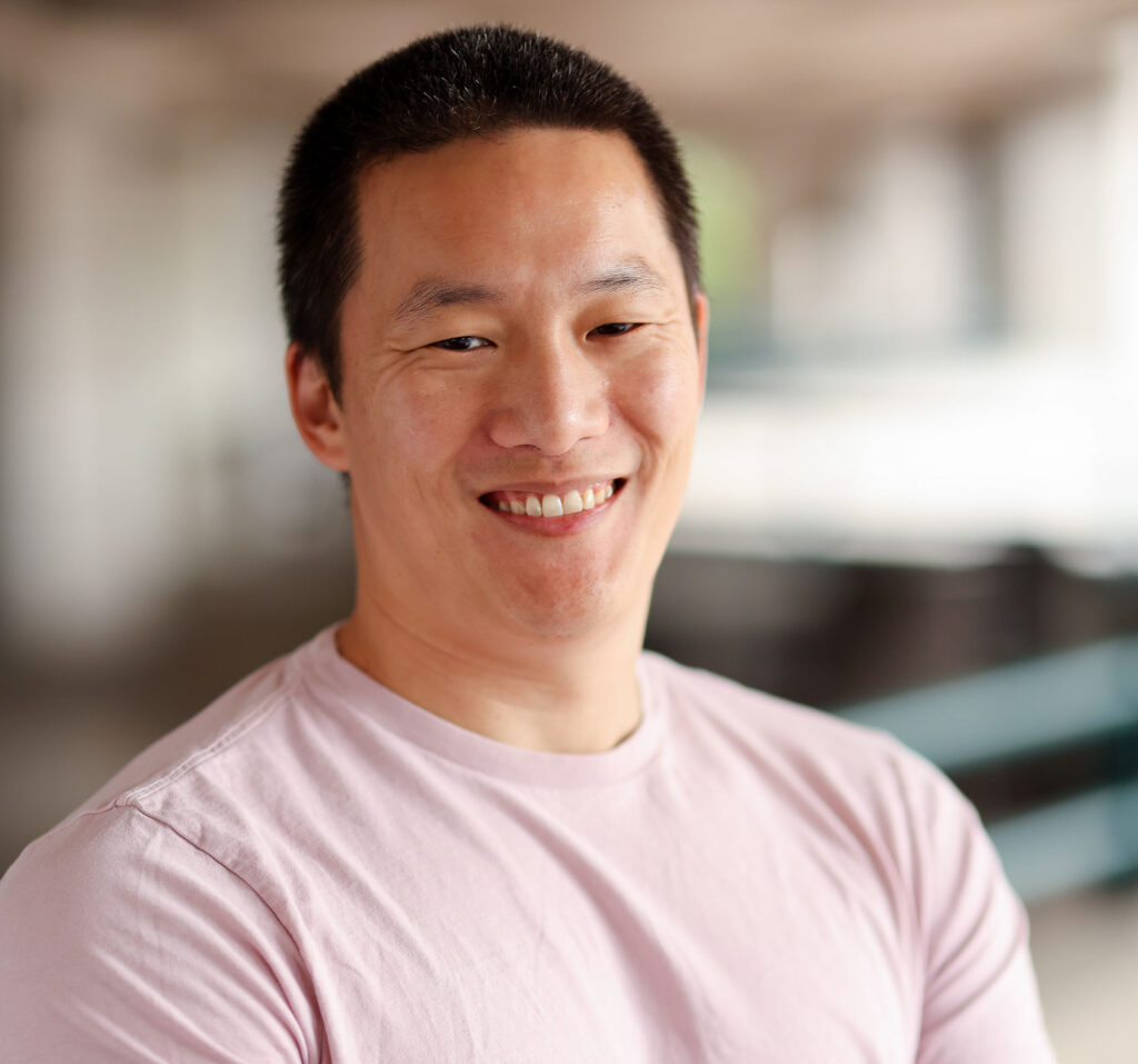 A photo of Jay Li, wearing a light pink shirt.