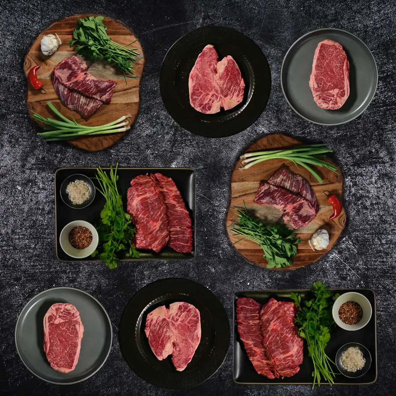 Assortment of Herd & Grace meats and vegetables displayed on plates and photographed from above